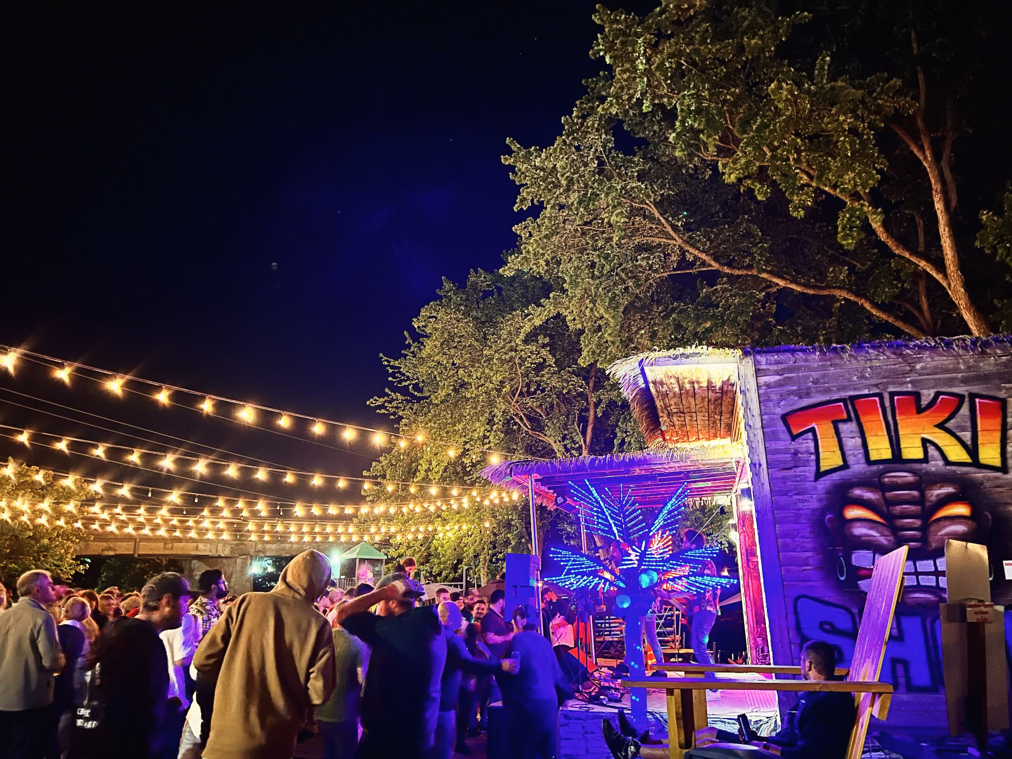 Foule réunie devant la scène illuminée du Tiki Show