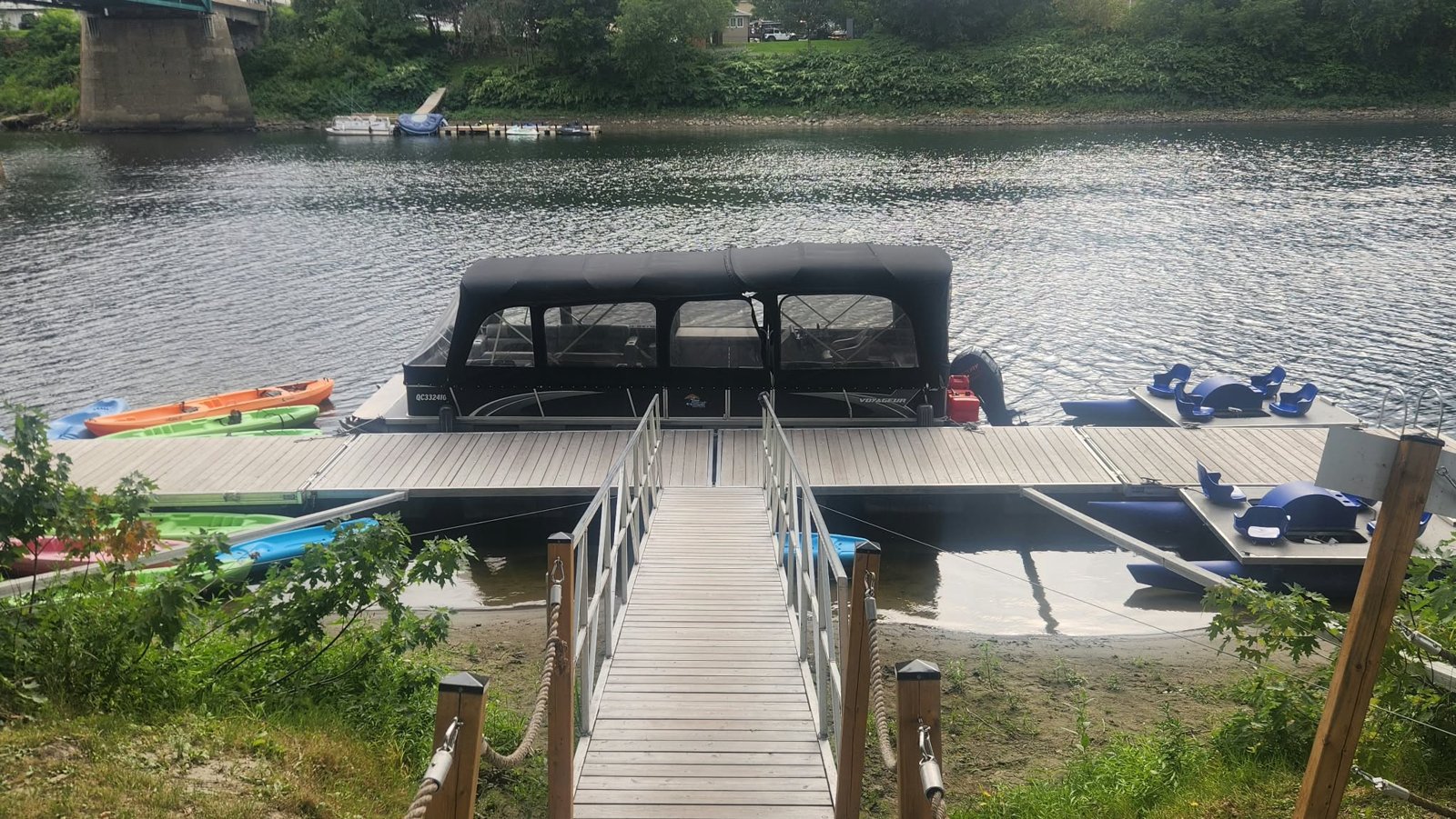 Ponton couvert amarré au quai, distinct des pédalos bleus